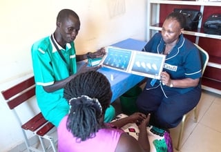 Midwife Peter Door explains family planning methods to a mother at a clinic in Rumbek.