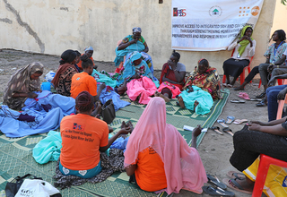 Women and girls gathered, knitting and making bedsheet weaving, at Hope Restoration South Sudan GBV response site- Renk