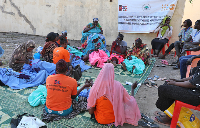 Women and girls gathered, knitting and making, bedsheet weaving, at Hope Restoration South Sudan GBV response site- Renk