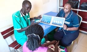 Midwife Peter Door explains family planning methods to a mother at a clinic in Rumbek.
