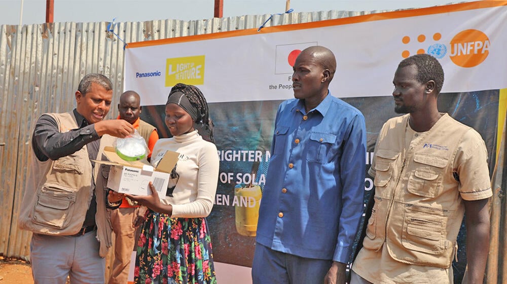 Dr. Hussein Hassan,  UNFPA emergency coordinator hands over solar lanten to a  beneficiary  at Juba  (IDP)  Camp