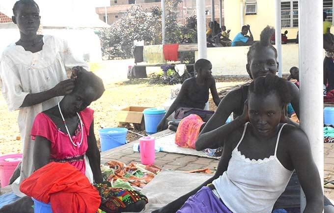 Women from Aweil fix each other's hair as they prepare to go home after their fistula repair surgery.